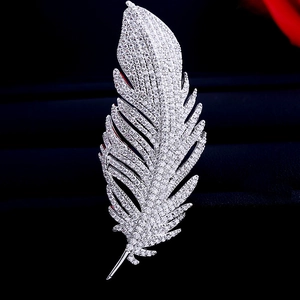Detailed macro shot of silver feather brooch with pavé-set sparkling zircons for women
