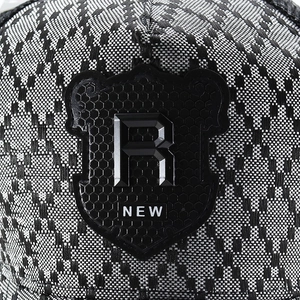 Detailed macro shot of a black and white checkered baseball cap with a 3D R shield emblem