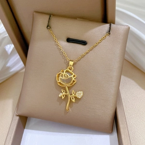 Close-up of golden rose necklace with cat eye stone and diamonds in a gift box