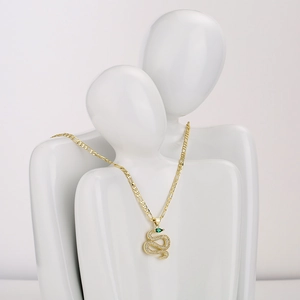 18K gold plated snake pendant necklace with green gemstone on abstract white sculpture