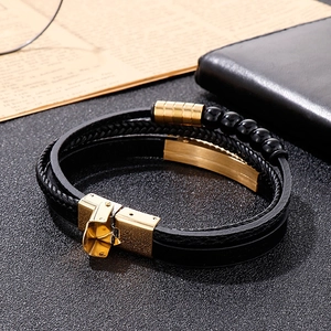 Detail of multi-layer black leather bracelet with gold stainless steel clasp and beads