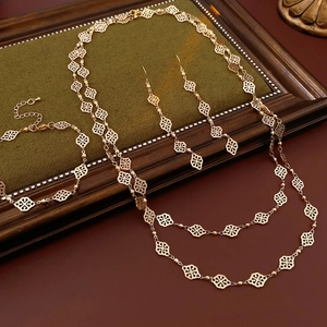 Vintage gold hollow diamond pendant necklace and earrings set on green velvet