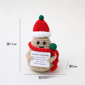 Detailed shot of cute crochet potato doll with Christmas hat and red scarf for decor.