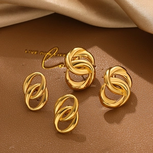 Macro detail of interlocked 18K gold double hoop earrings on silk background