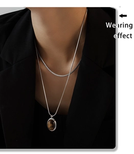 Detail einer silbernen Schlangenkette mit Tigerauge-Stein im Doppel-Lagen-Look