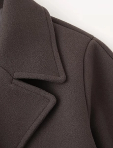 Detail of wide lapel collar and precision stitching on dark brown wool coat