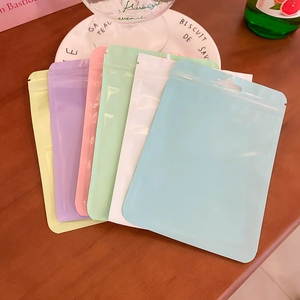 Fan-shaped display of colorful pastel matte resealable storage bags on a wooden table