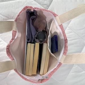 Spacious striped canvas tote bag interior with zipper showing iPad and daily essentials
