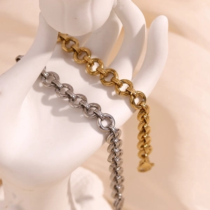 Detailed close-up of chunky gold and silver round link chains on a white hand model