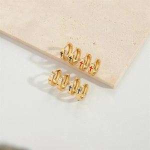 Set of four pairs of gold cross huggie hoop earrings in black, red, white, and blue enamel