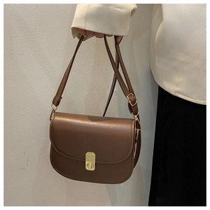 Detailed view of brown faux leather crossbody bag with golden twist lock and adjustable strap