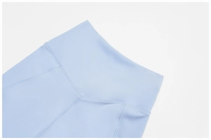 Close-up of high-waisted sky blue yoga pants featuring flatlock seams and supportive waistband