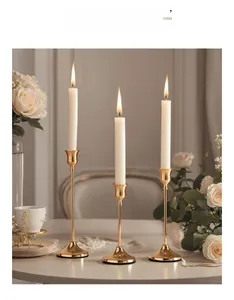 Detailed view of three gold metal candle holders with white candles in a luxury setting