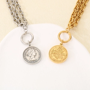 Detail of layered stainless steel coin pendant bracelets with OT buckle in gold and silver