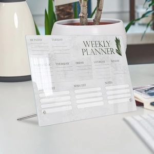 Weekly planner acrylic memo board with marble pattern and metal stand on office desk