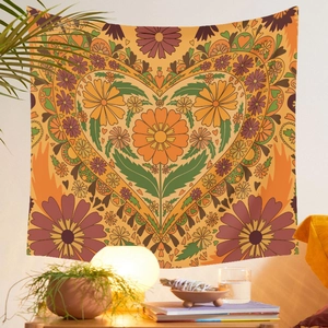 Retro 70s style tapestry with a floral heart design displayed in a cozy living room scene