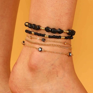 Set de 5 tobilleras bohemias con cuentas de piedra negra y dijes dorados del ojo turco