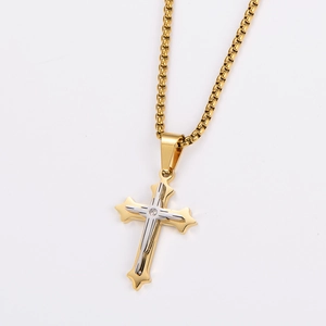 Macro view of two-tone gold and silver cross pendant with central zircon gemstone