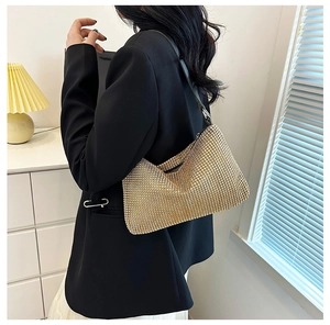 Close-up of sparkling champagne gold rhinestone hobo bag with black leather shoulder strap