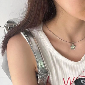 Minimalist silver star pendant on a fine ball chain worn by model for y2k fashion style
