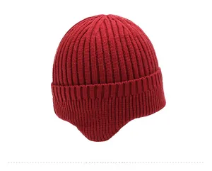 Detail view of the thick ribbed knit texture and earflap design on a dark red winter hat