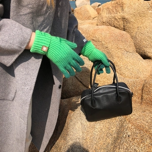 Green ribbed knit gloves with leather logo patch styled with a black leather Boston bag