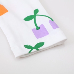 Macro detail of white cotton knit fabric featuring a modern purple cherry geometric print