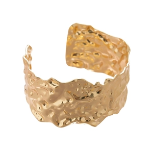 Minimalist wide open gold cuff bracelet with luxury hammered metal finish and wavy edges