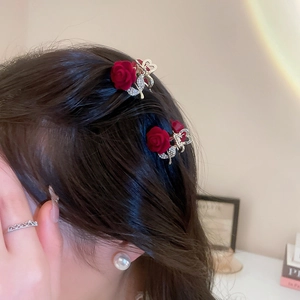 Close-up of elegant red velvet rose hair claw clips with sparkling rhinestones details