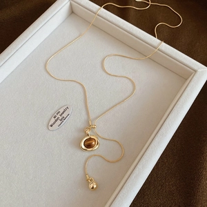 Close-up of heart-shaped tiger eye stone pendant on a gold snake chain necklace