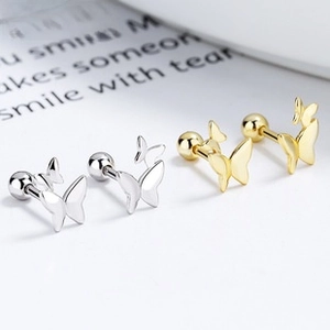 Detail view of gold and silver butterfly screw-back studs with polished finish