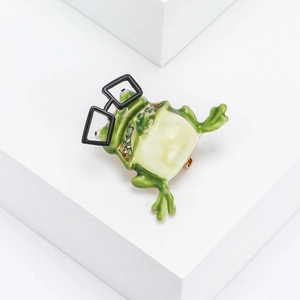 Whimsical green enamel frog brooch wearing black square glasses with green crystals