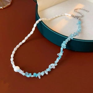 Detail of seashell aquamarine necklace with white seed beads and light blue stones
