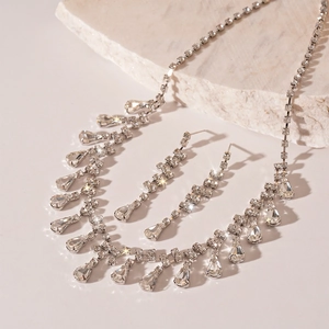 Macro detail of silver-toned jewelry set with teardrop crystals and sparkling rhinestones