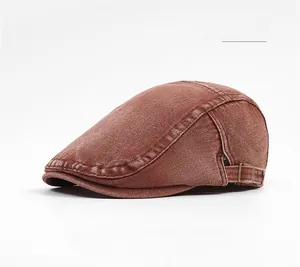 Detail of dark red washed cotton newsboy cap with metal buckle and contrast stitching