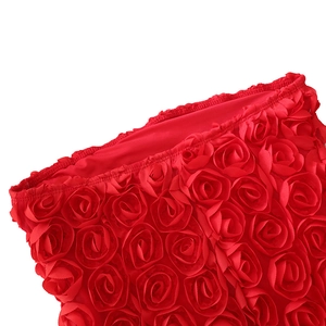 Détail des décorations de roses rouges en 3D sur le bord d'une robe bustier chic