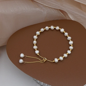 Detail of freshwater pearl bracelet with gold metal beads and adjustable pull chain