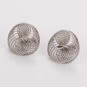 Macro shot of silver intertwined metal wire spherical earrings with a high-polish finish