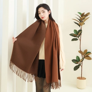 Detail view of thick brown cashmere-feel scarf showing soft texture and tassel fringe