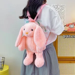 Rear view of a pink plush bunny backpack with adjustable straps on a female model