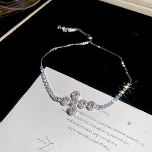 Detailed close-up of a zircon cross bracelet with pink stones and adjustable clasp