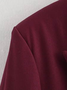 Dettaglio della cucitura della spalla del blazer bordeaux e tessuto twill