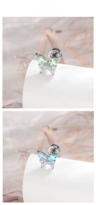 Macro shot of butterfly cartilage stud earrings with green and blue zircon gemstones