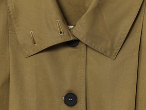 Detail of khaki olive coat featuring black resin buttons and high-density twill fabric