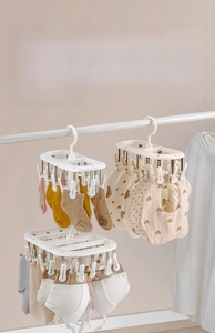 Detailed view of cream white drying rack with multi-clips for baby socks and underwear