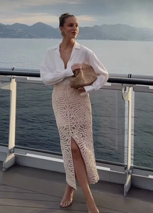 Détail de la chemise blanche et jupe mi-longue en crochet beige avec fente latérale