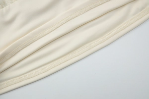 Close-up of high-quality stitching and ivory lace fabric detail on backless tank top