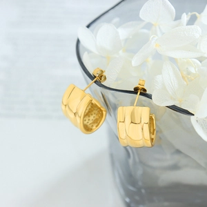 Minimalist gold plated stainless steel C-shape chunky hoop earrings on a glass rim