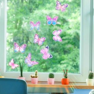 Rainbow butterfly window decals on glass with a scenic green outdoor garden background