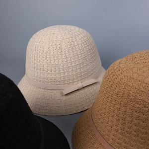 Three knitted sun hats in white, khaki and black colors with elegant bow ribbon details